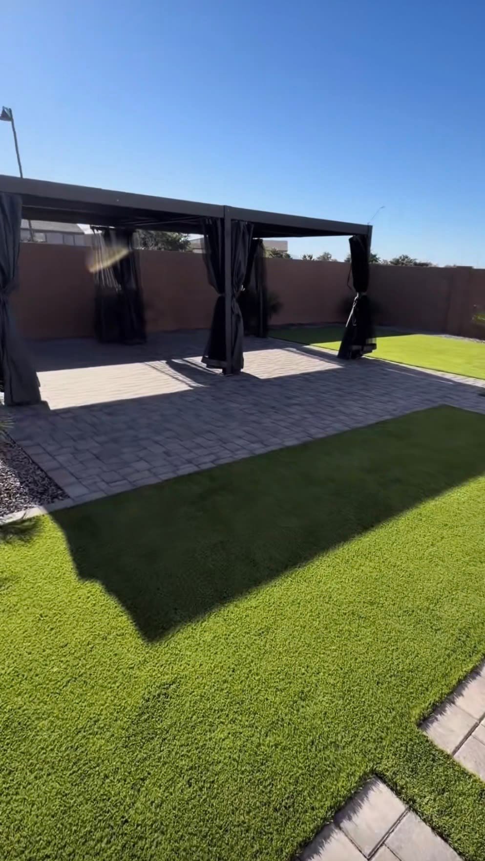 Backyard turf and paver patio with pergola
